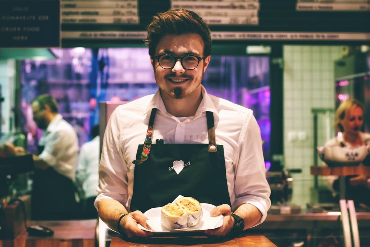 A smiling server presenting a dish